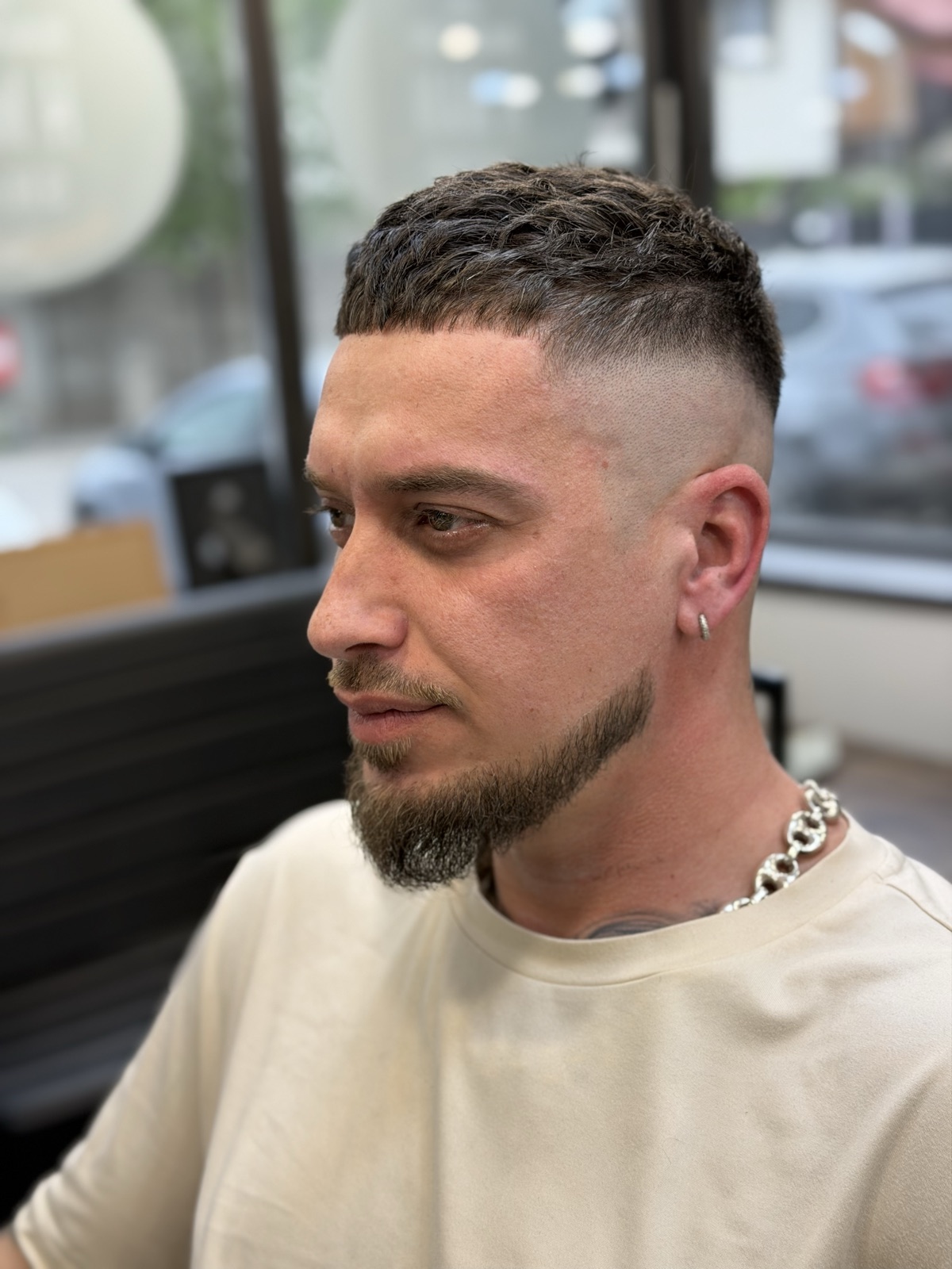 High skin fade cu top texturat scurt și barbă sculptată